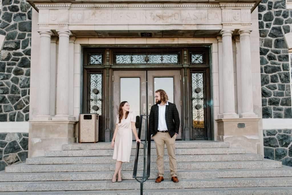 Couple posing side by side on a set of steps.