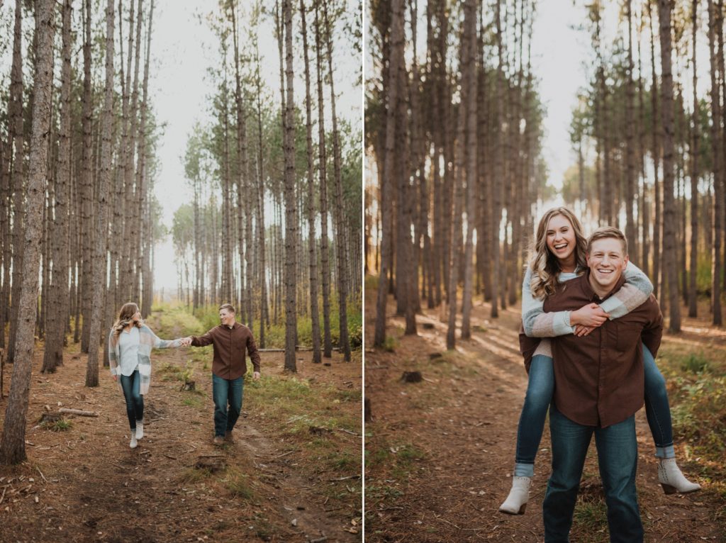 Couple walking through wooded area holding hands.