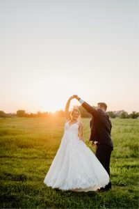 Bride and groom dancing at sunset